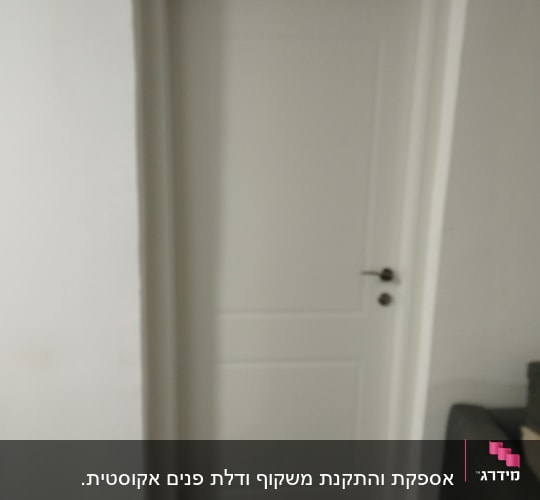 דלת לבנה עם ידית מתכת על קיר לבן